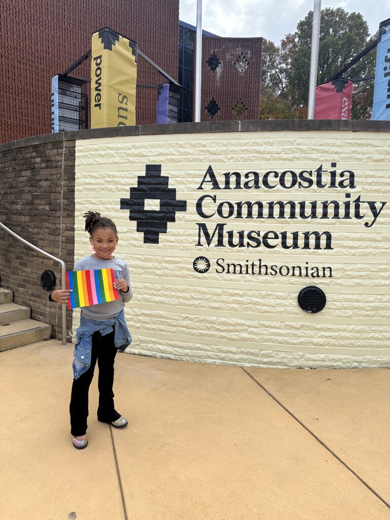 A girl standing in front of the Anacostia Community Museum.