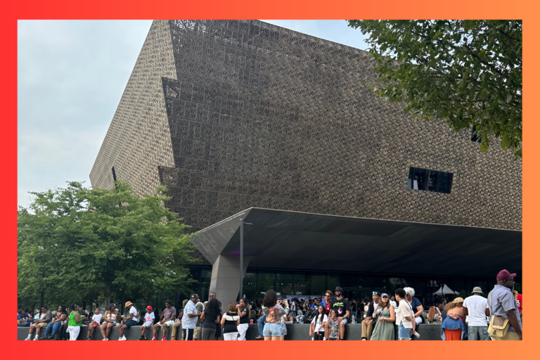 the building of the National Museum of African American History and Culture with a bunch of people standing outside of it