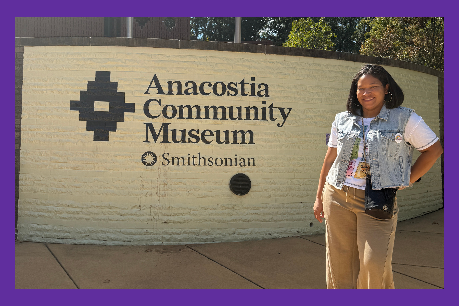 Sarah standing in front of a sign at the Anacostia Community Museum