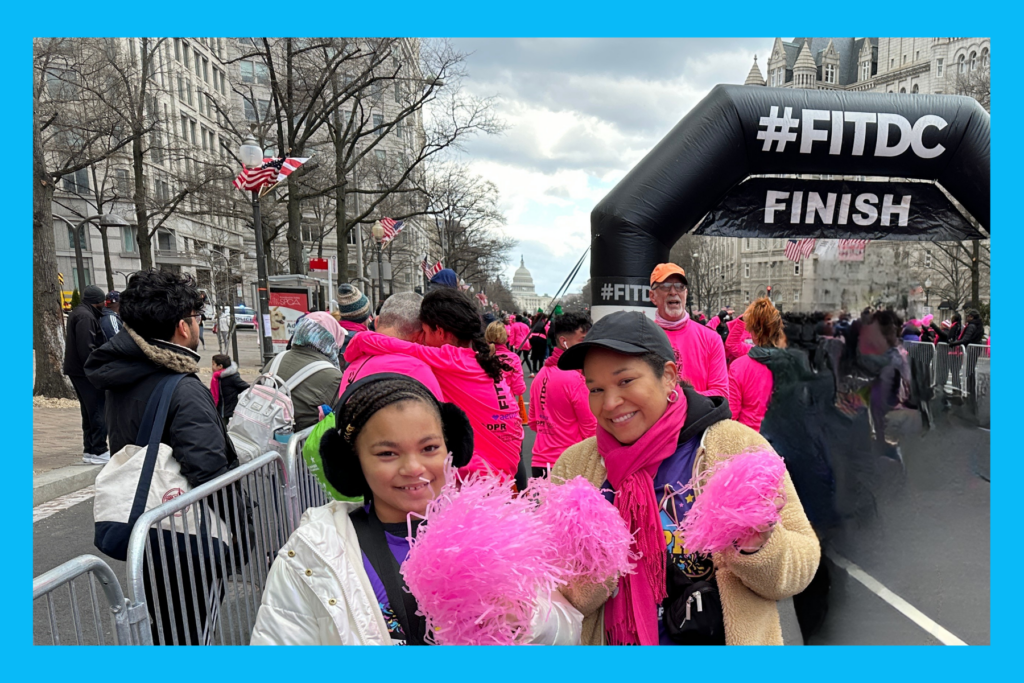 Sarah and Liv at the Herstory 5K with pink pom poms in 2025