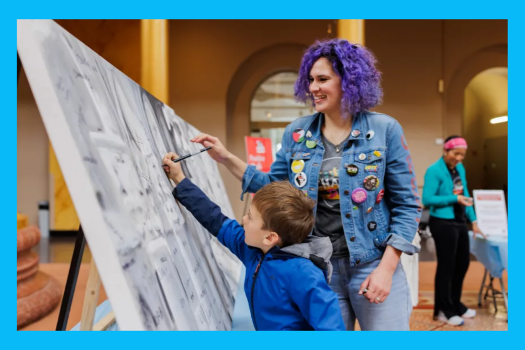 Val of Positive Chalk draws with a child at The Big Draw at the National Building Museum