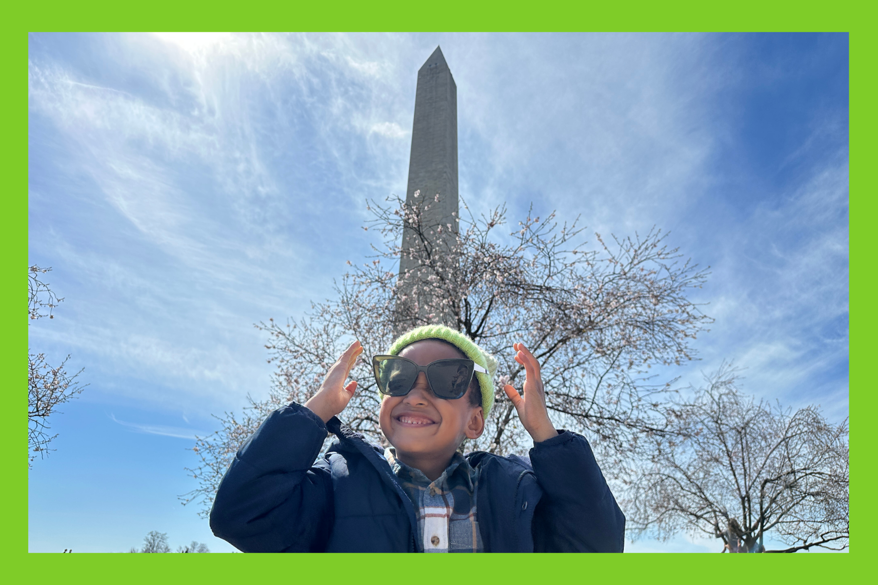 Jackson smiles in front of cherry blossoms at the Washington monument