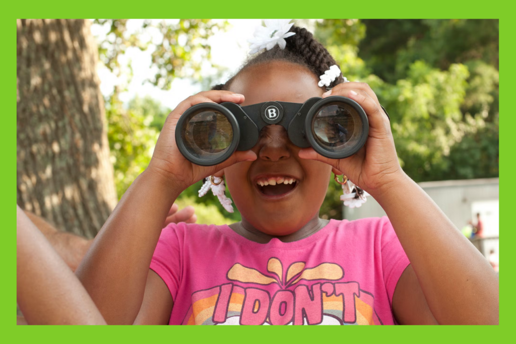 girl looking through binoculars