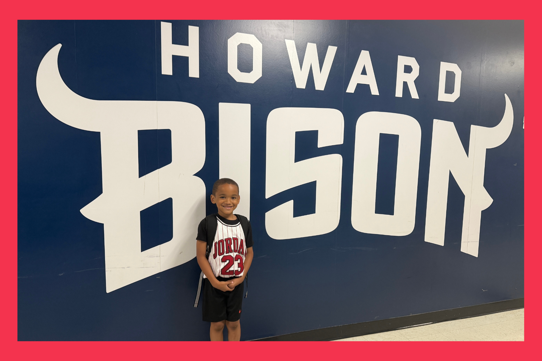 young boy in front of Howard Bison sign.