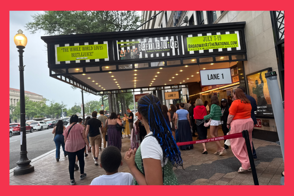 kids look up at Beetlejuice the sign at The National Theatre