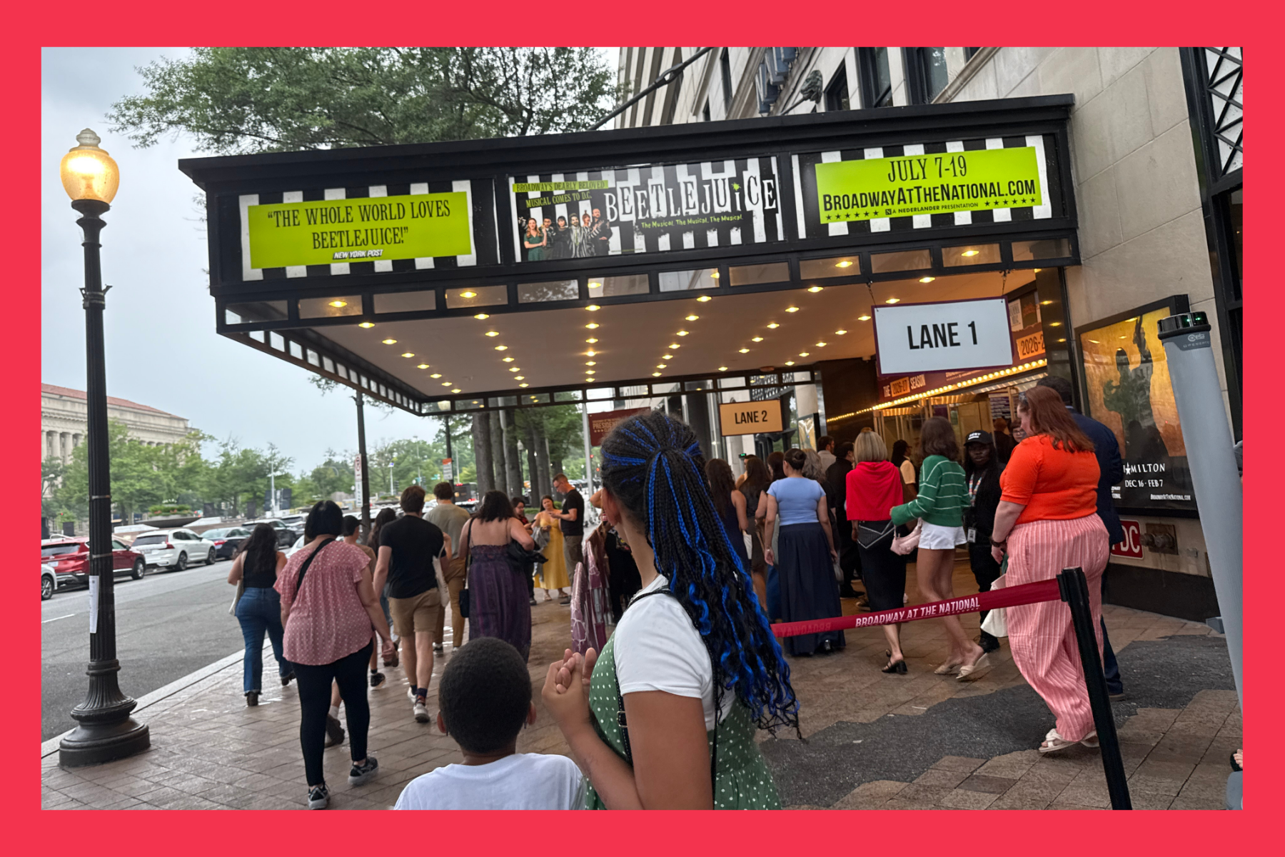 kids look up at Beetlejuice the sign at The National Theatre