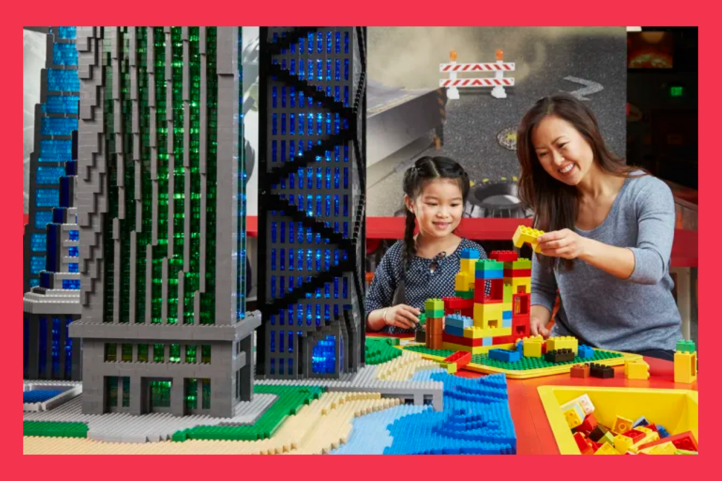 mom and daughter play with legos at the LEGO Discovery Center.