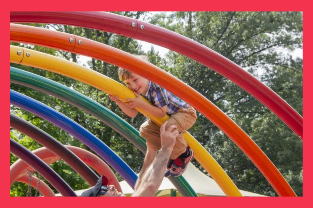 A child enjoying a rainbow play structure.