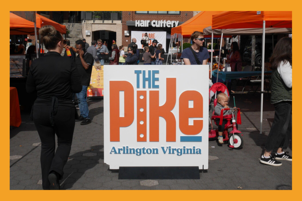 "The Pike" sign in front of a busy street festival.