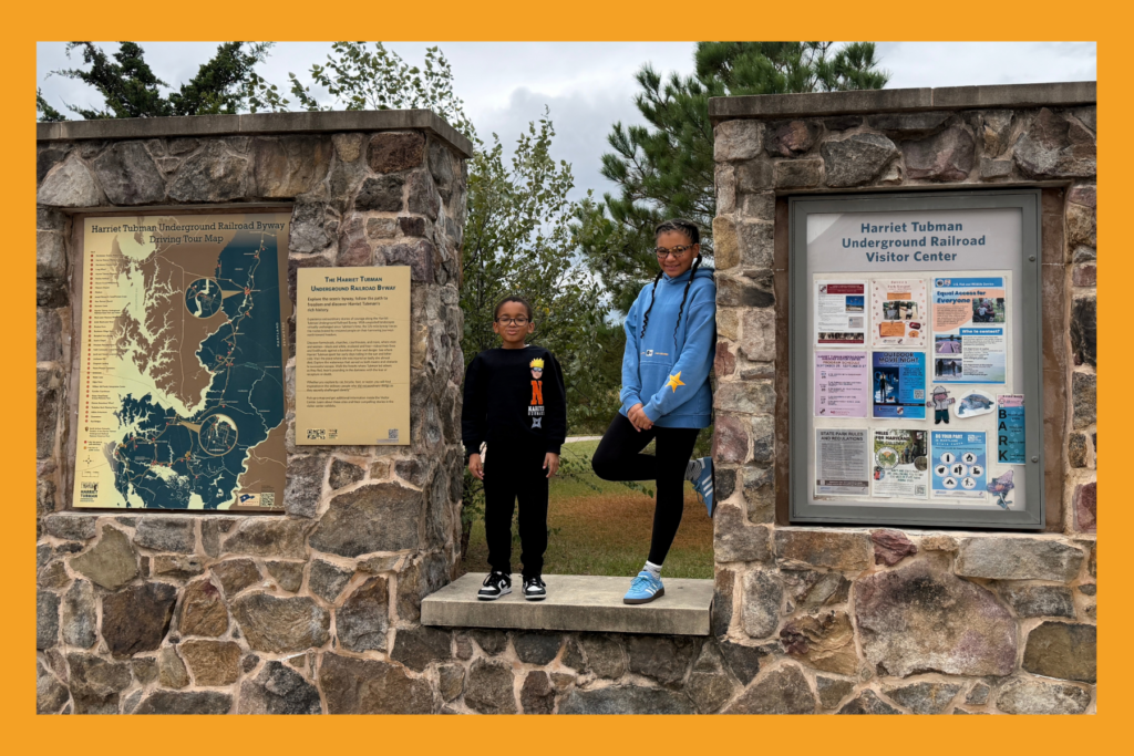 two young kids pose at the Harriet Tubman Underground Railroad byway driving tour map.